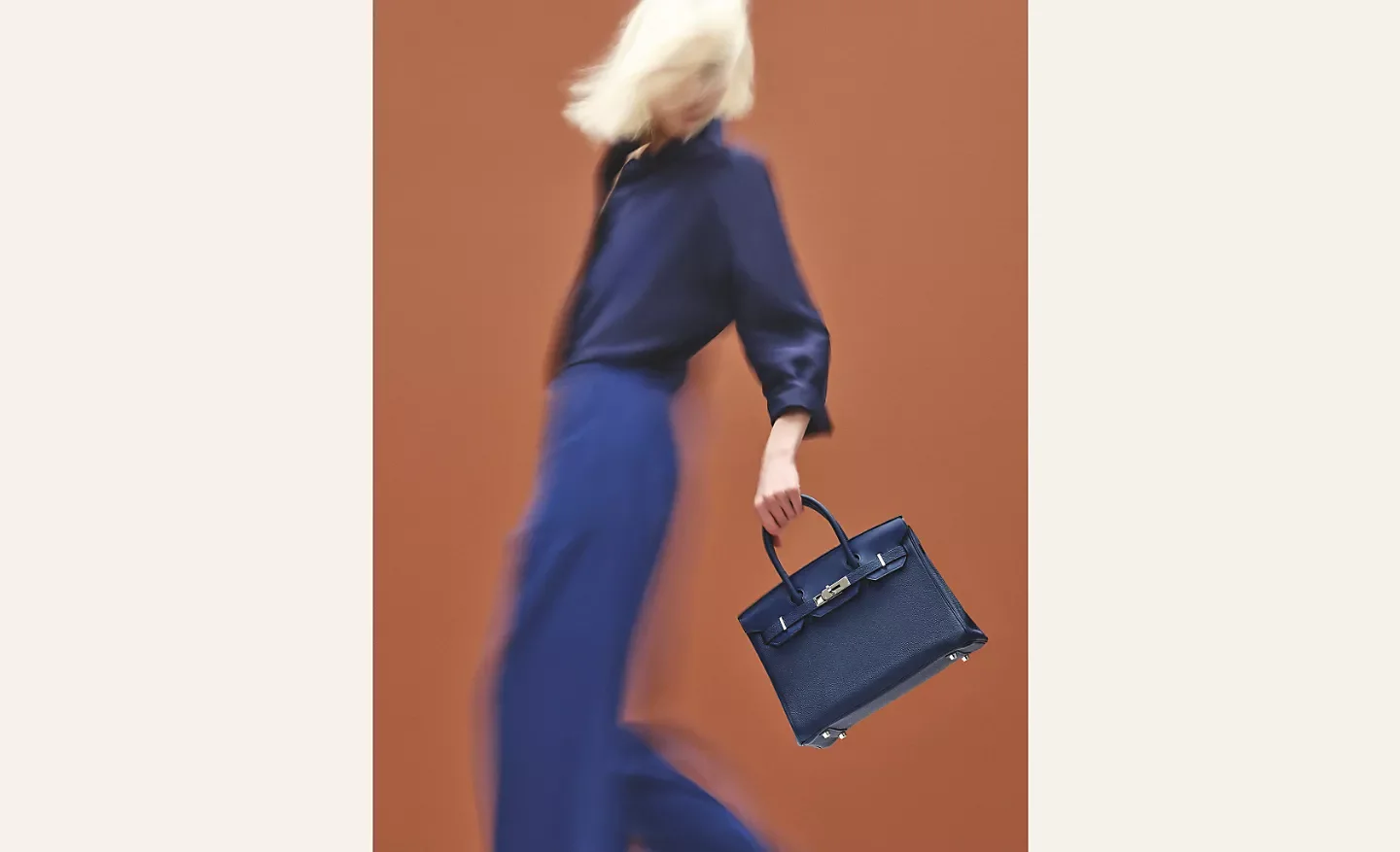 High-society collector evaluating options to buy designer bags for resale inside a luxury walk-in closet